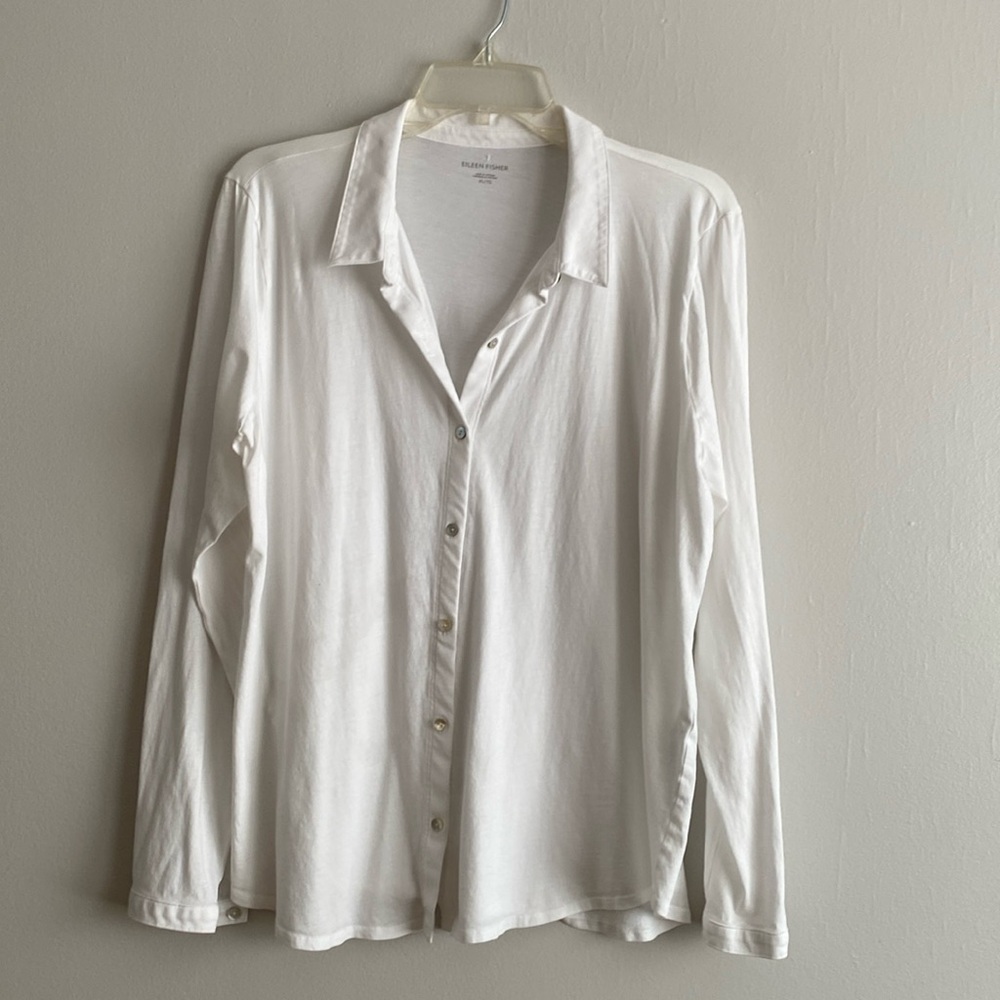 Eileen Fisher's white shirt has a tiny sewn-in hole, invisible under the collar.
